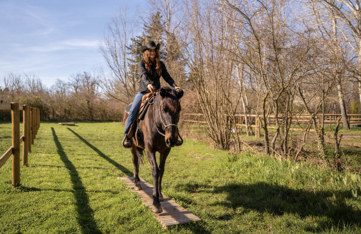 Elodie à cheval sur Guevara franchissant une passerelle en Mountain Trail