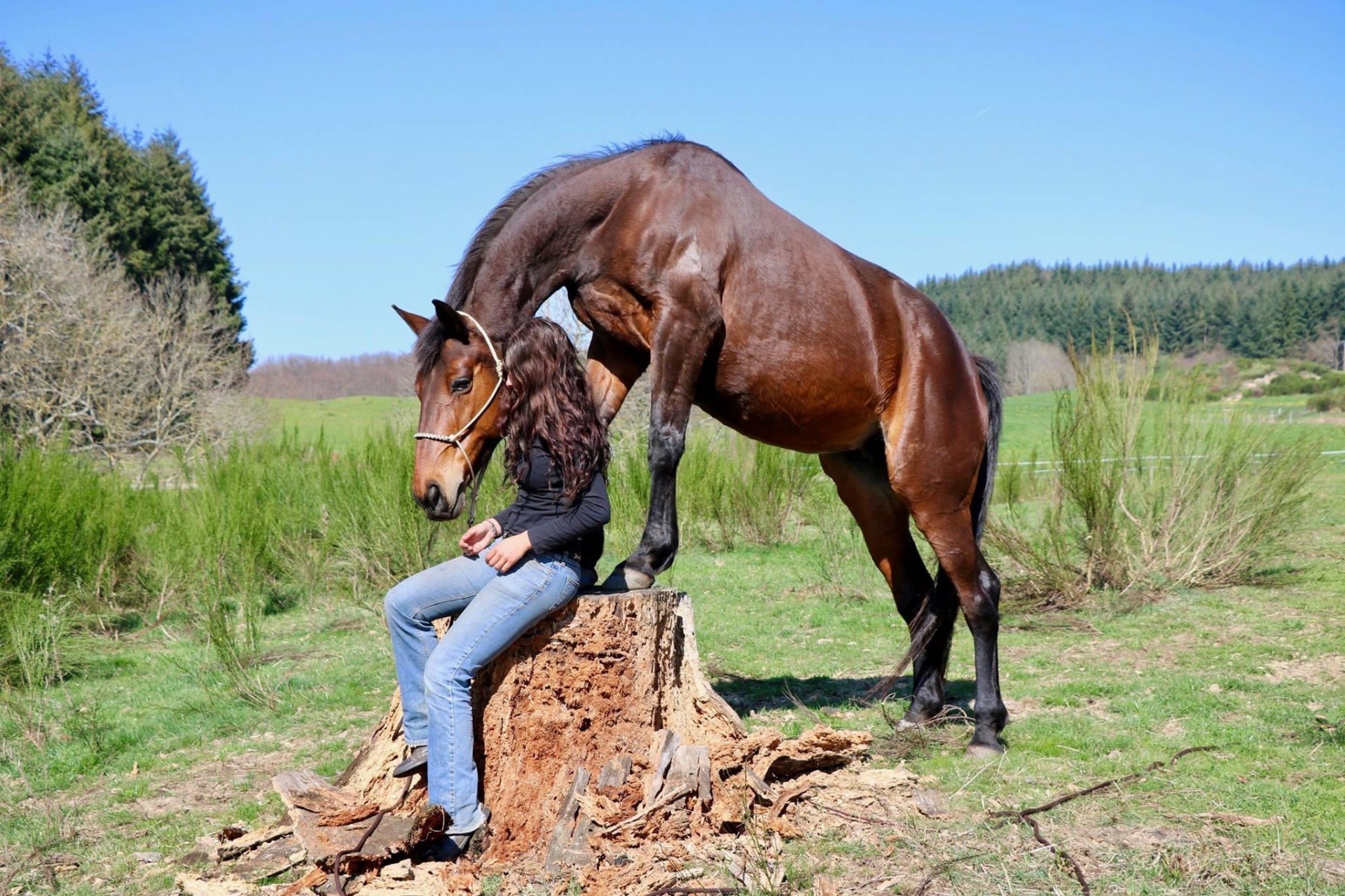 Élodie assise sur une souche avec son cheval